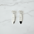 Silver CC logo oval mirror drop earrings on white marble