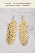 Oversized Gold Feather Drop Earrings large flat lay on marble background