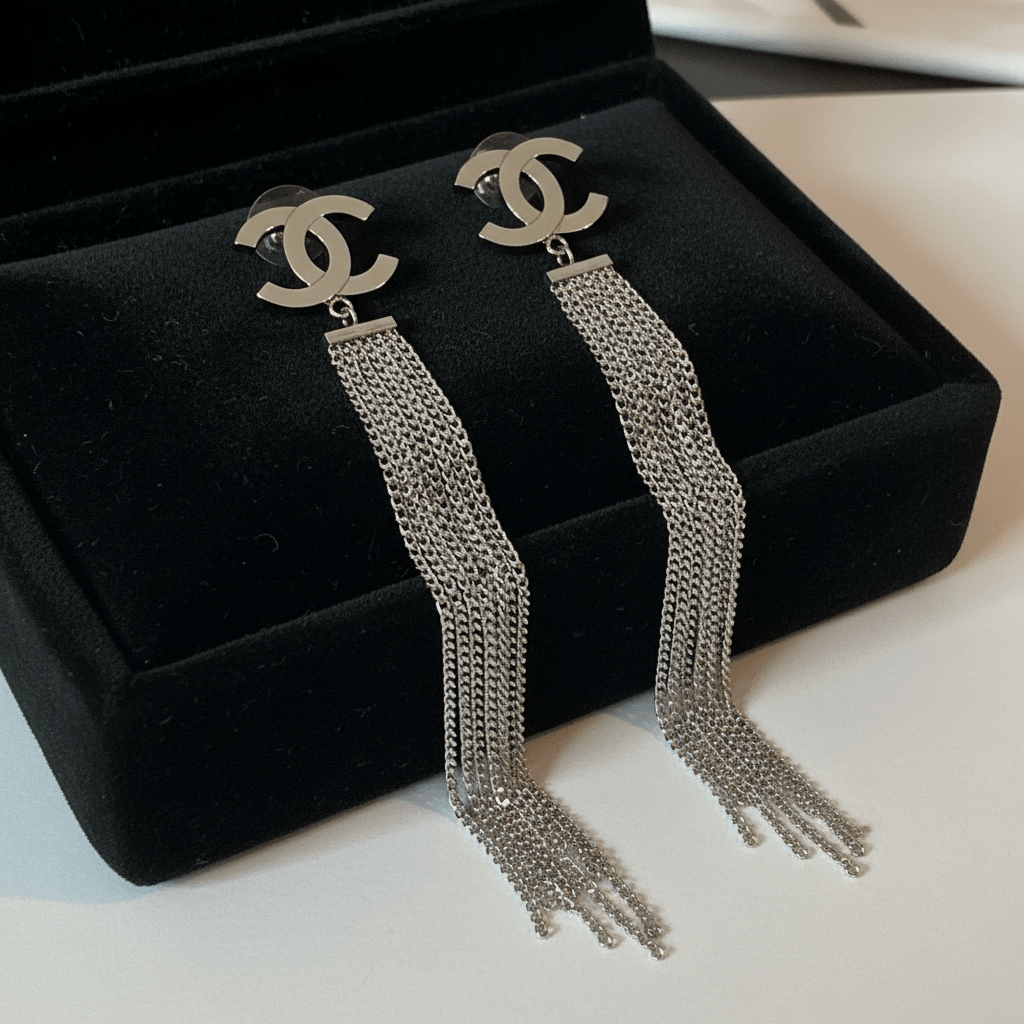 Silver CC logo chain fringe earrings on black velvet tray
